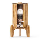 Ein Stand-Wasserfilter aus massivem Akazienholz mit einem Glasbehälter, sichtbaren Filterkartuschen und einem Zapfhahn aus Edelstahl.