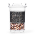 Eine transparente Wasserfilter-Kartusche, die im oberen Bereich mit Aktivkohle und im unteren Bereich mit Mineralkugeln gefüllt ist.